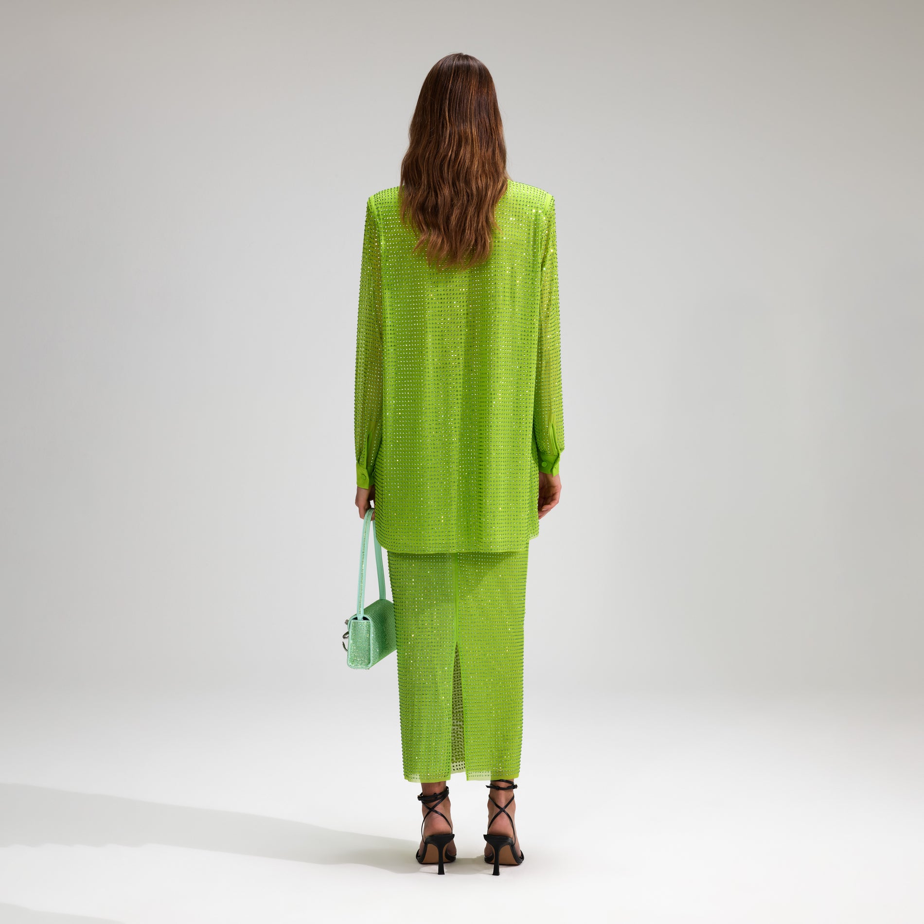 A woman wearing the Green Rhinestone Mesh Midi Skirt