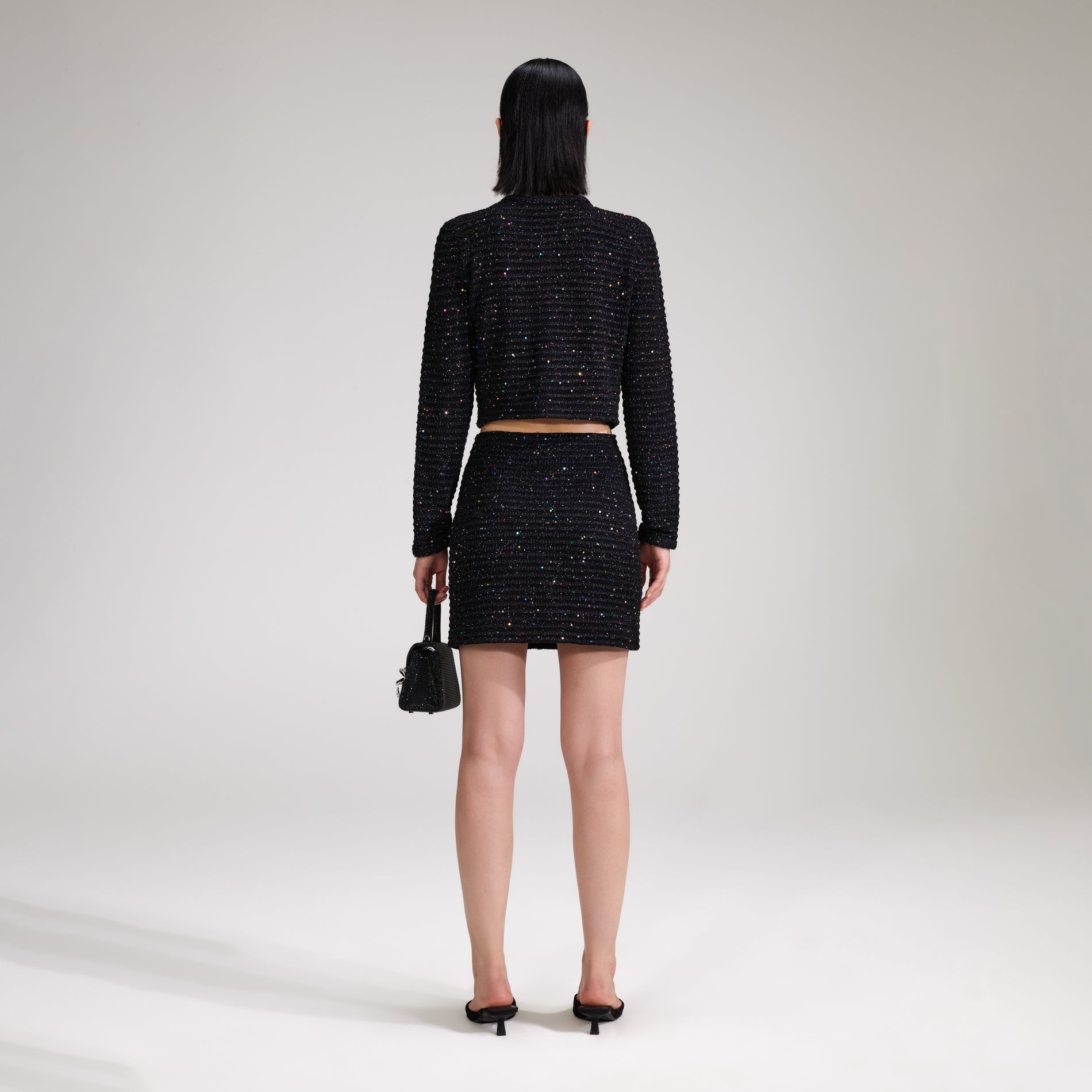 A woman wearing the Black Sequin Knit Skirt